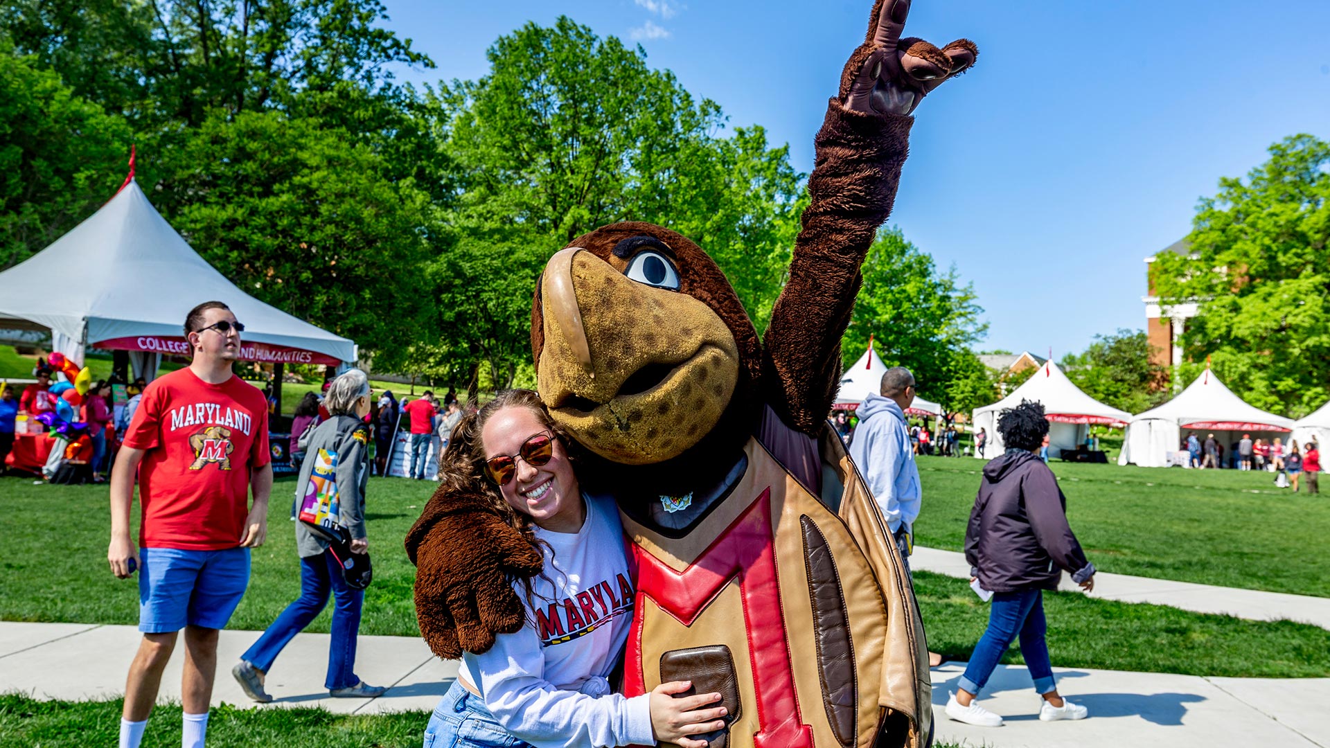 A young student hanging out with Testudo on McKeldin Mall at Maryland Day.