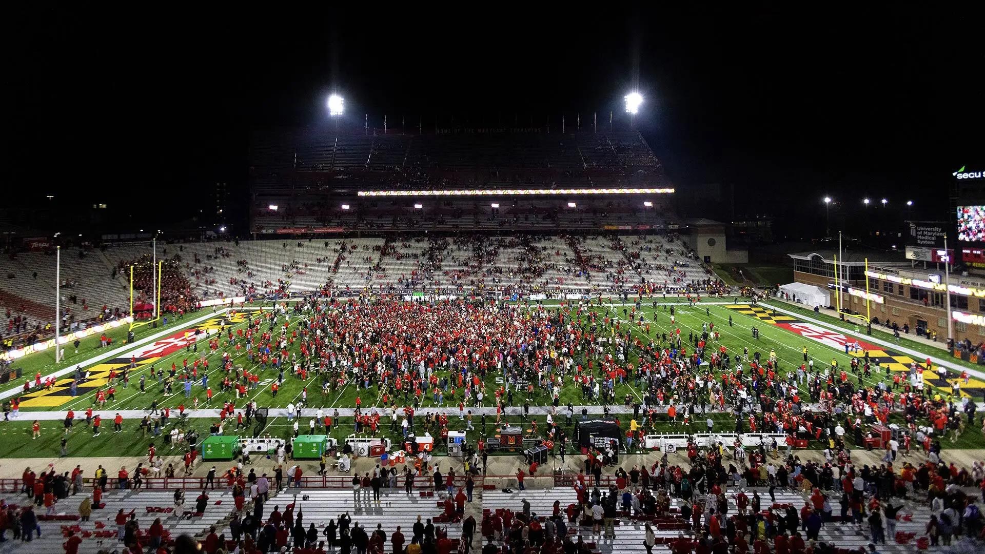 Terps fans storm the field at SECU Stadium on Oct. 19 after the football team’s dramatic 29-28 Homecoming Game victory over USC in the debut meeting between the teams. Photo by Riley N. Sims.