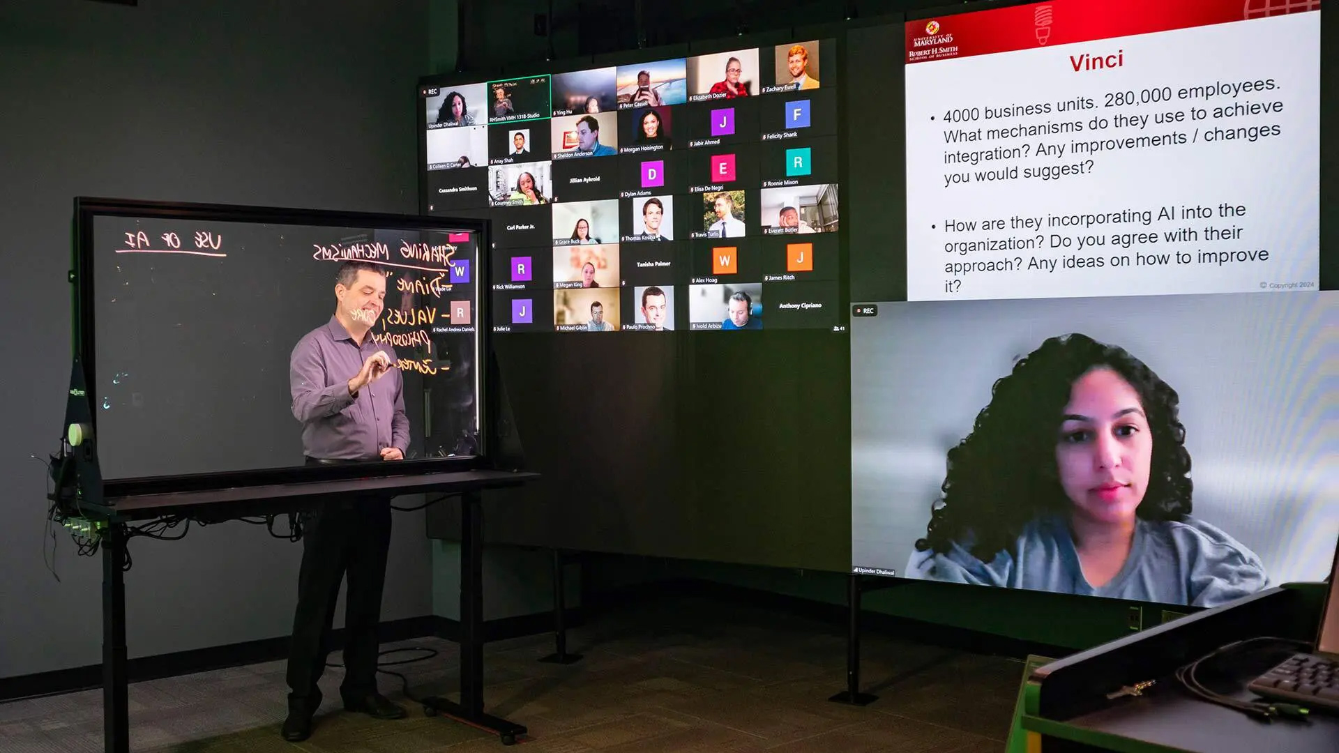 Clinical Professor Paulo Prochno interacts with students while writing on a lightboard in a new high-tech virtual classroom facility in the Robert H. School of Business that was funded by a gift from Bill Boyle '81. It's the first teaching facility of its kind on the UMD campus.