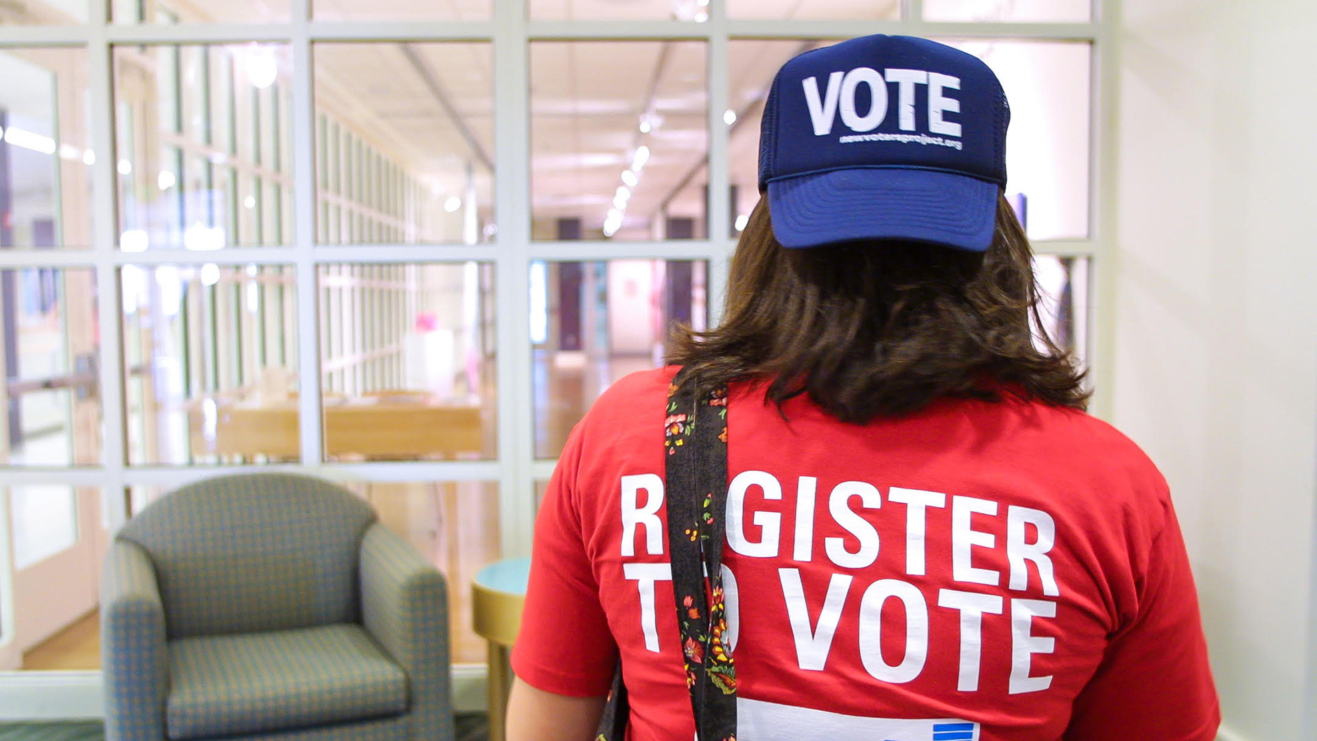 Election volunteer wearing a "Vote" hat and a "Register to Vote" shirt.