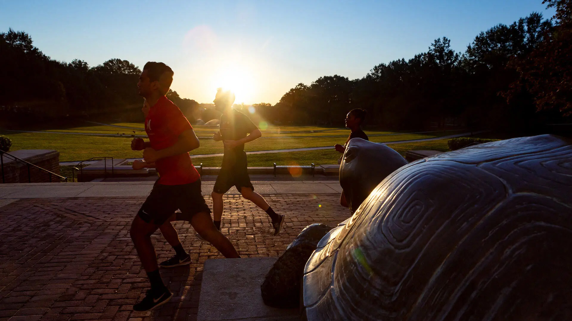 ROTC cadets run laps around McKeldin Mall during sunrise. Balancing three-day-a-week physical training, labs and off-site field exercises with college classes sets students up to become military officers after graduation. Photo by Stephanie S. Cordle.